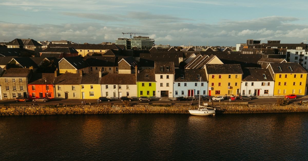 Park House Hotel in Galway: A Cornerstone of City Centre Hospitality Since 1975 Aerial view of colorful houses along a river in Galway, Ireland at daytime.