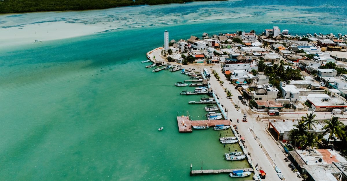 Fort George Hotel & Spa in Belize City: A New Luxury Stay Stunning aerial view of a coastal town with turquoise waters and vibrant landscape, highlighting a charming waterfront.