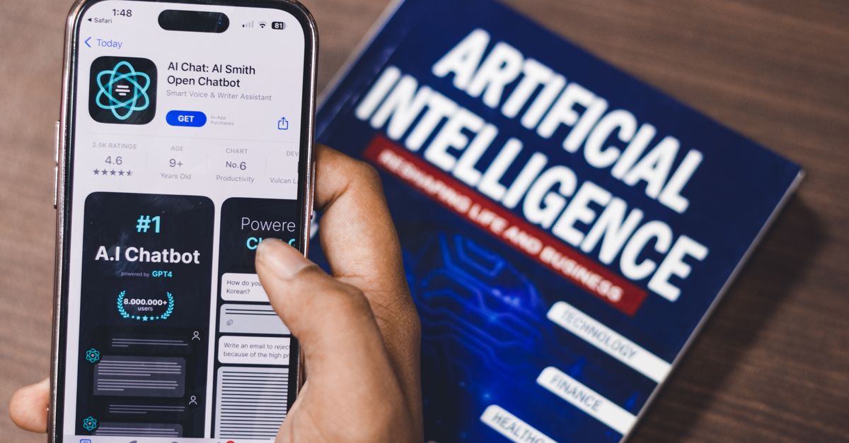 Oracle Books $6.9 Billion Defense Deal While Battling Wisconsin Collateral Bill, Credit Downgrade and Nvidia–OpenAI Backstop Report Smartphone displaying AI app with book on AI technology in background.