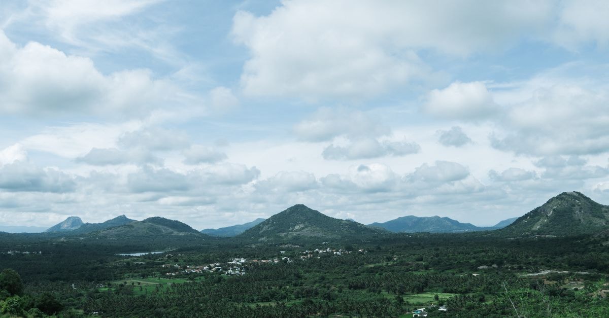 Panoramic view of lush green hills under a cloudy sky in Bengaluru, Karnataka.