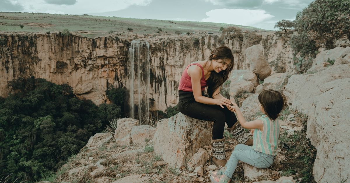 Ihosy Travel Guide: A Thoughtful Stop on the Way to Isalo Mother and child bonding outdoors near a scenic waterfall, enjoying nature.