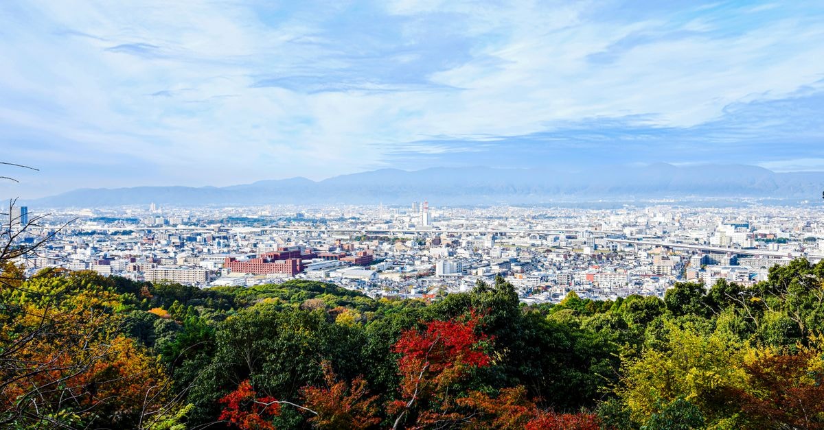 Court Hotel Asahikawa in Asahikawa: A 114-Room Hub in Central Miyamae A breathtaking view of Kyoto's skyline surrounded by vibrant autumn foliage, as seen from Fushimi Inari Shrine.