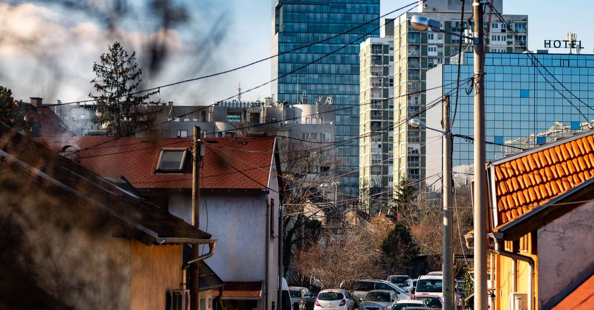 A scenic view of Zagreb showcasing urban buildings and residential houses under a clear sky.