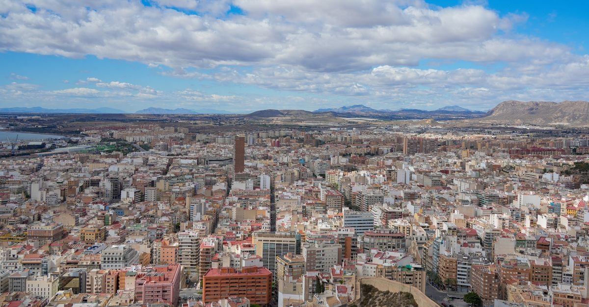 Hotel Melilla Puerto in Melilla: Beachside Stay by the Marina Expansive aerial cityscape view of Alicante, Spain on a clear day with blue skies and scattered clouds.