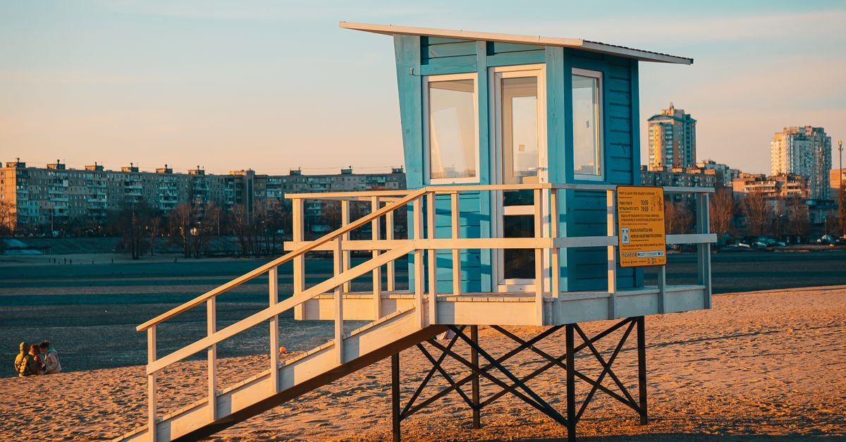 Smolensk Travel Guide: Quiet Heritage on the Upper Dnieper A serene sunset casts warm tones on a blue lifeguard stand at Kyiv beach.