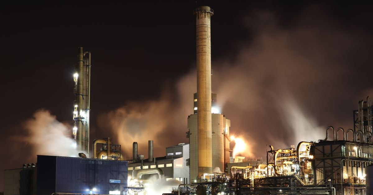 Energy Fuels Closes $299M Australian Strategic Materials Deal, Adding Korean Metals Plant and Dubbo Project A nighttime view of an industrial factory with smokestacks emitting smoke, highlighting energy production and pollution.