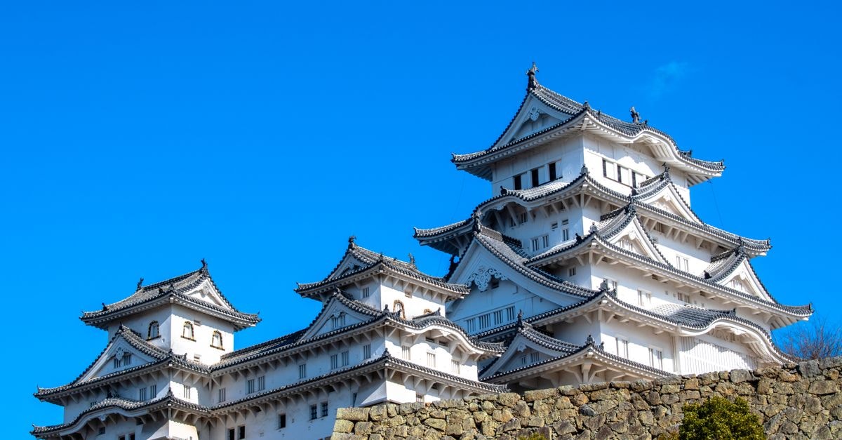 Himeji Travel Guide: Japan's White Castle, Koko-en Gardens, and Regional Cuisine Stunning view of Himeji Castle in Kyoto, Japan under a clear blue sky.