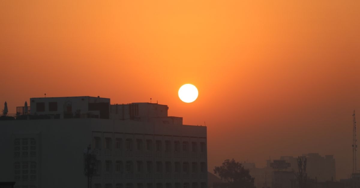 德里都市建築上空迷人的橘紅色夕陽景緻。
