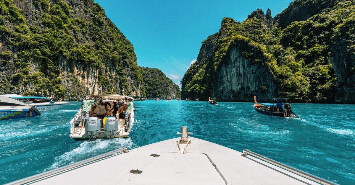 Vibrant boat tour through stunning Krabi limestone cliffs in Thailand.