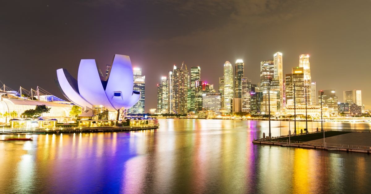Hotel Clover The Arts in Singapore: An Art-Themed Boutique Stay Between Two Quays Night view of Singapore's illuminated skyline and Marina Bay Sands, reflecting vibrant city lights.