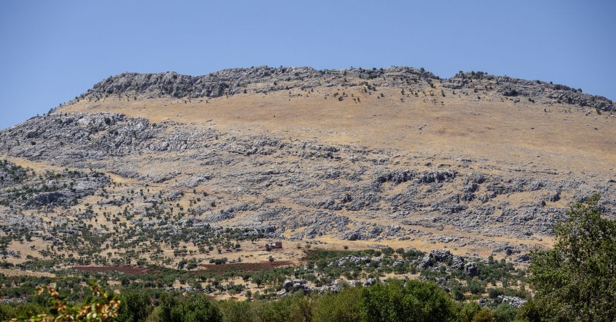 Djelfa at a Glance: A High Plateau Travel Guide Beautiful rocky hills with sparse greenery in Çermik, Diyarbakır, Turkey under a clear blue sky.