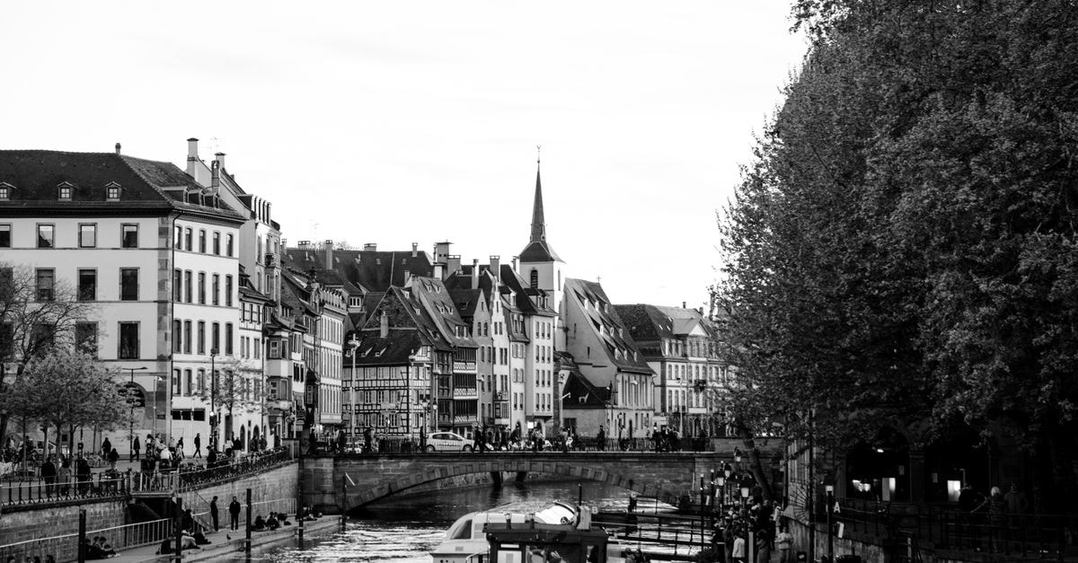 Captivating black and white view of Strasbourg canal with iconic architecture and lively streets.