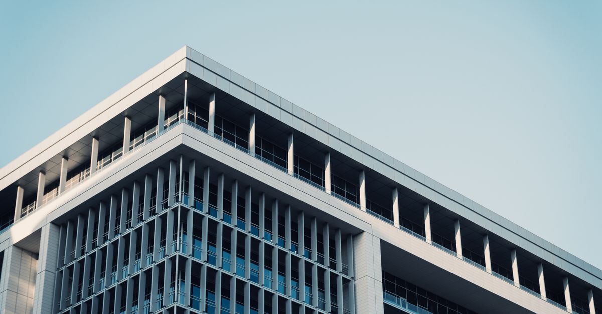 Build-A-Bear Workshop: Experience-Driven Retail at a Cyclical Crossroads Contemporary office building with a futuristic glass facade reflecting the sky.
