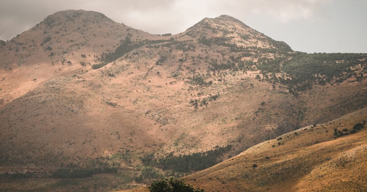 A Quiet Corner of the Plateau: Things to Do in Bouar Serene mountain landscape with rolling hills under a cloudy sky.