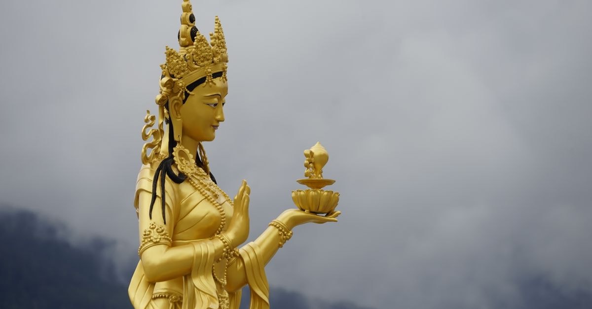 Hotel Kisa, Thimphu: Where Peace Prevails Above the Archery Ground Majestic golden statue of a Buddhist deity in Thimphu, Bhutan against a cloudy sky.