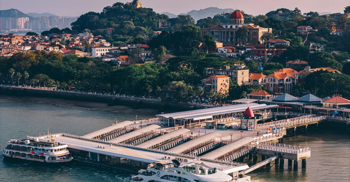Shantou Travel Guide: Planning Tips, Costs and Things to Do Aerial photograph showcasing the bustling harbor of Gulangyu Island with ferries and lush landscapes.