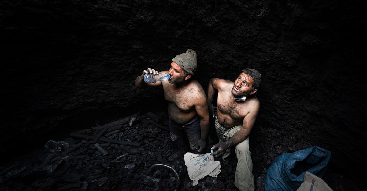 Coal India Posts 8.4% Production Growth in July as Mine-Safety and Methane Reports Surface Two shirtless miners taking a break in a dark coal mine in Iran.