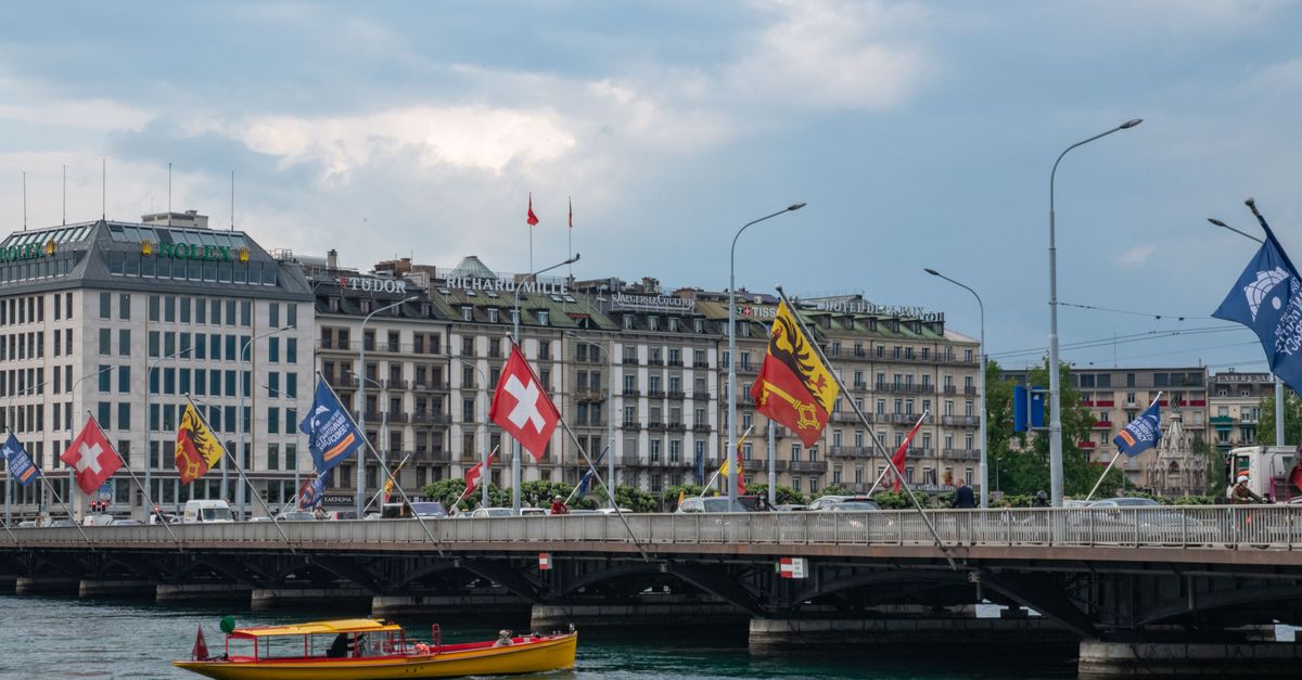 Geneva in July 2026: A Practical Travel Guide for Festival Season Capture of Mont-Blanc Bridge with flags and cityscape in Geneva, Switzerland.