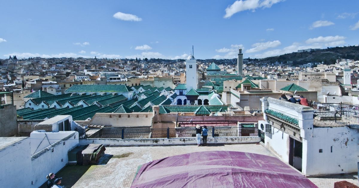 Sweeping view over Fès Medina with traditional architecture under a blue sky.