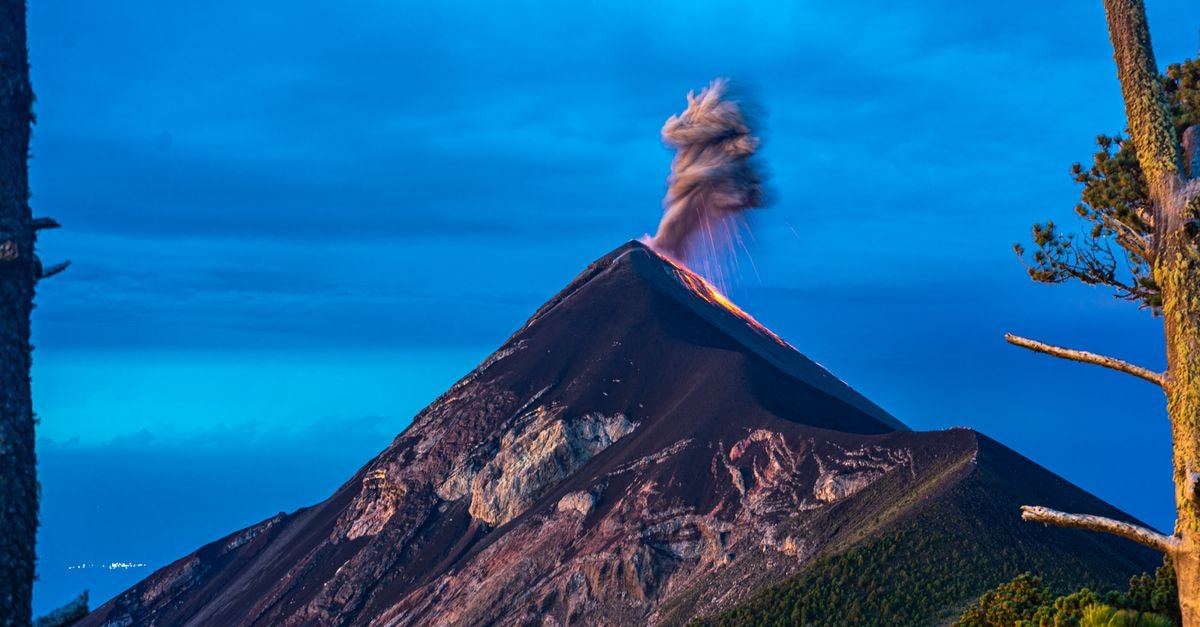 Dynamic capture of Volcán de Fuego erupting at twilight, showcasing the volcano's explosive power and dramatic landscape.