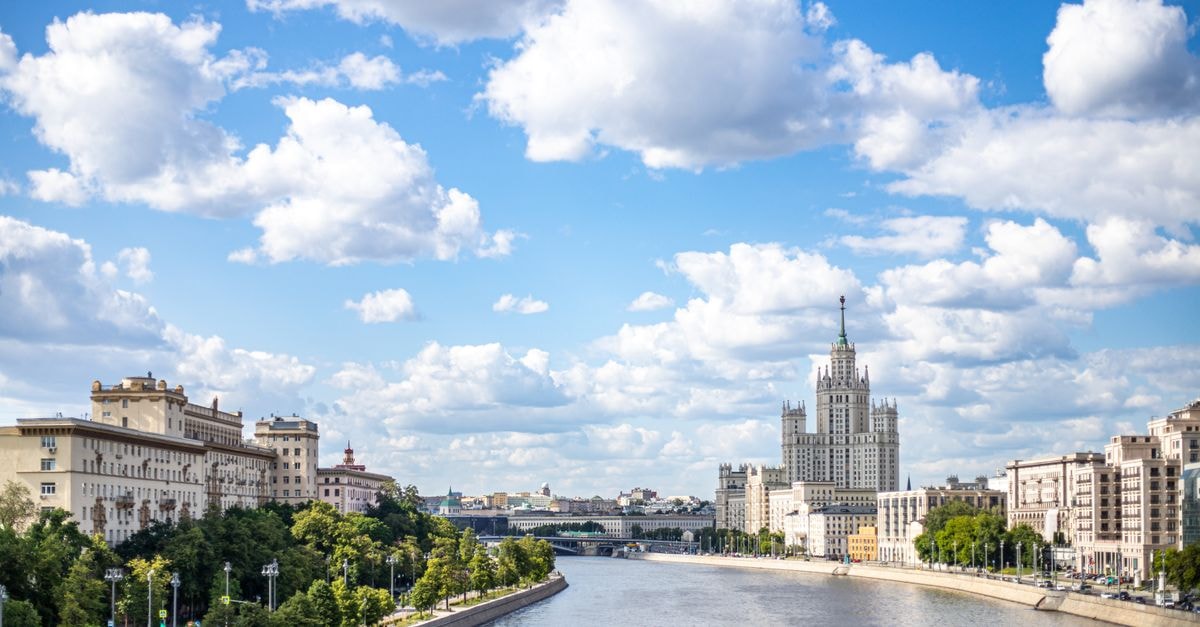 Four Seasons Hotel Moscow, Russia — Heritage Stay by Manezhnaya Square Panoramic view of Moscow cityscape featuring the Kotelnicheskaya Embankment against a bright summer sky.