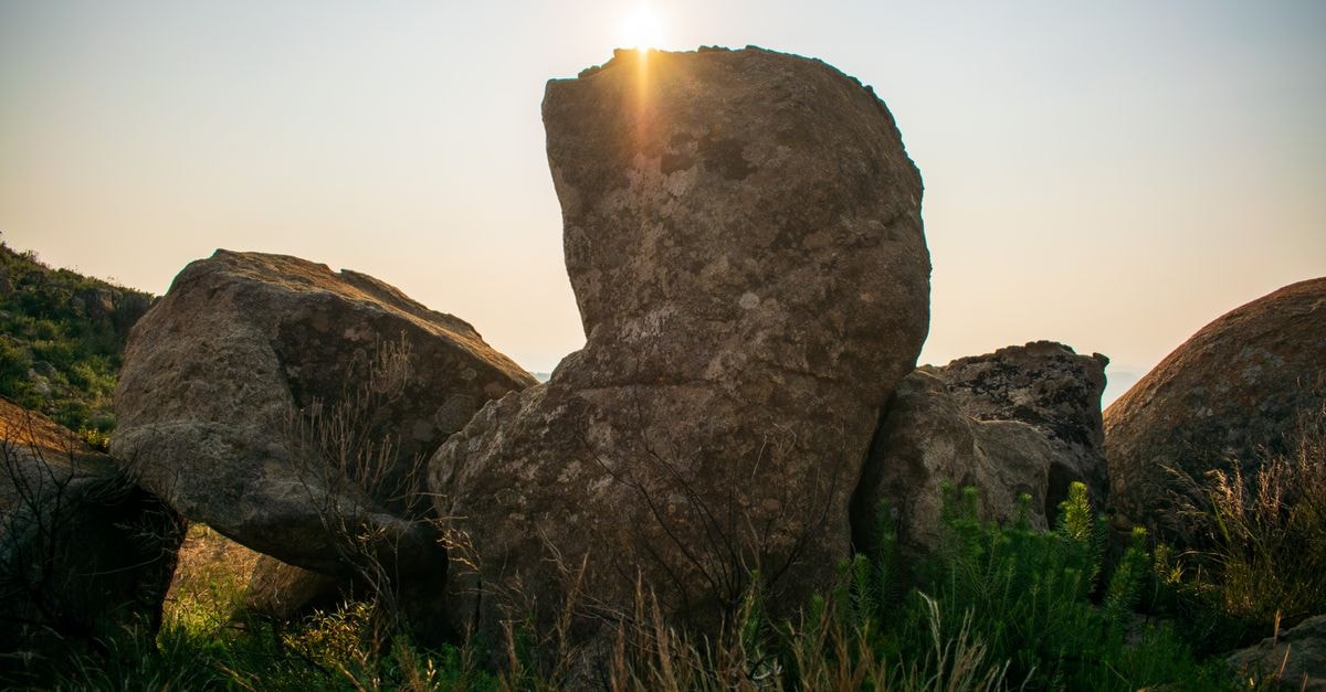 Jwaneng Travel Guide: Botswana's Diamond Heart in the Valley of Stars A stunning view of sunlit rock formations amidst lush greenery at sunset.