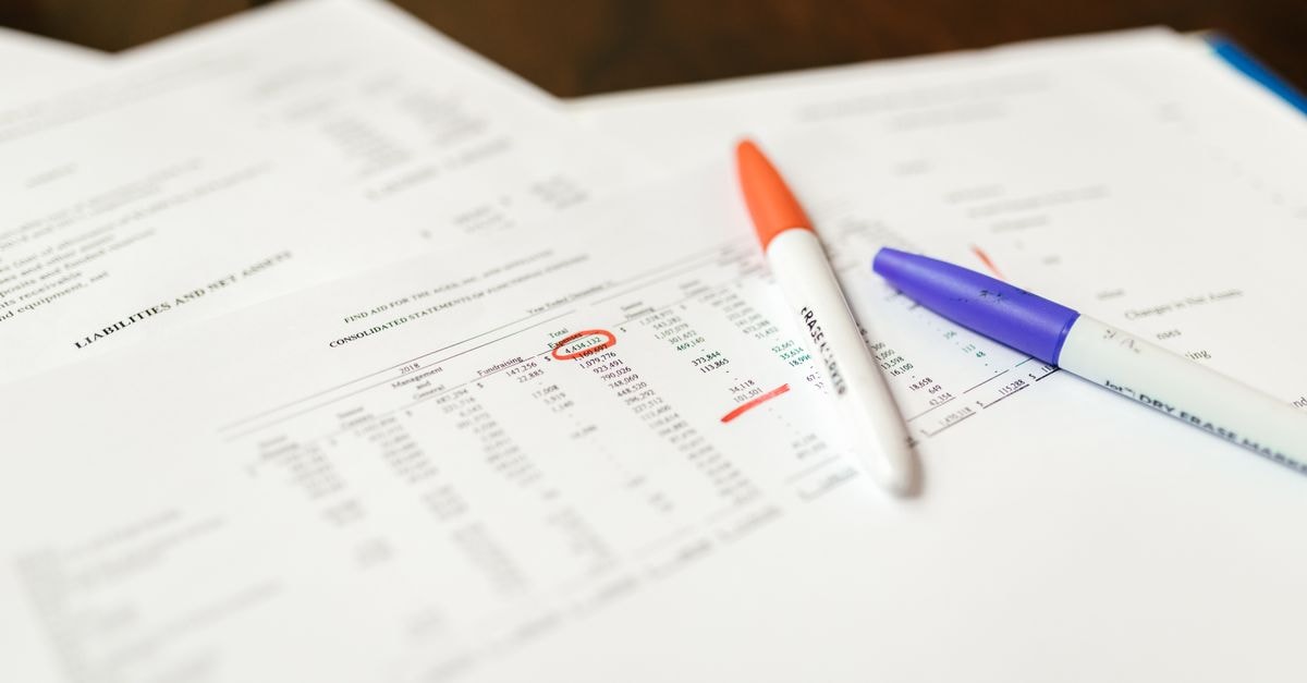 約 700 億美元表外 AI 債務保證引起債券投資人疑慮 近距離拍攝的金融文件,搭配原子筆標註重要數據重點。