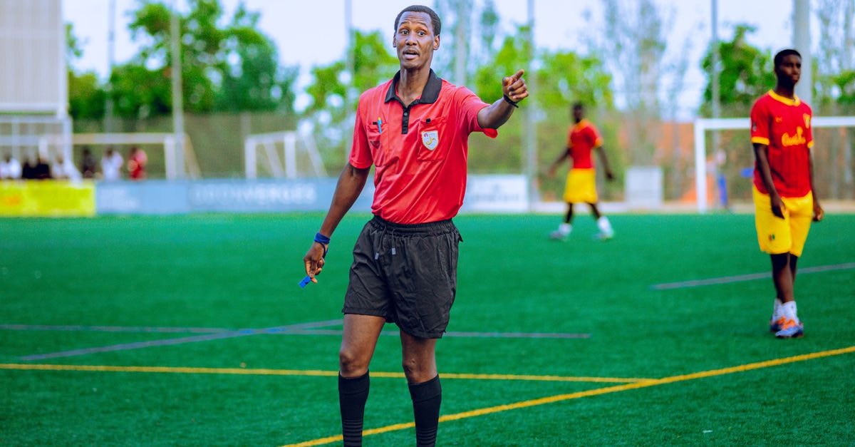 NHL referee Garrett Rank wins fourth Canadian men's mid-amateur golf title Soccer referee in action on field during a match, guiding players.