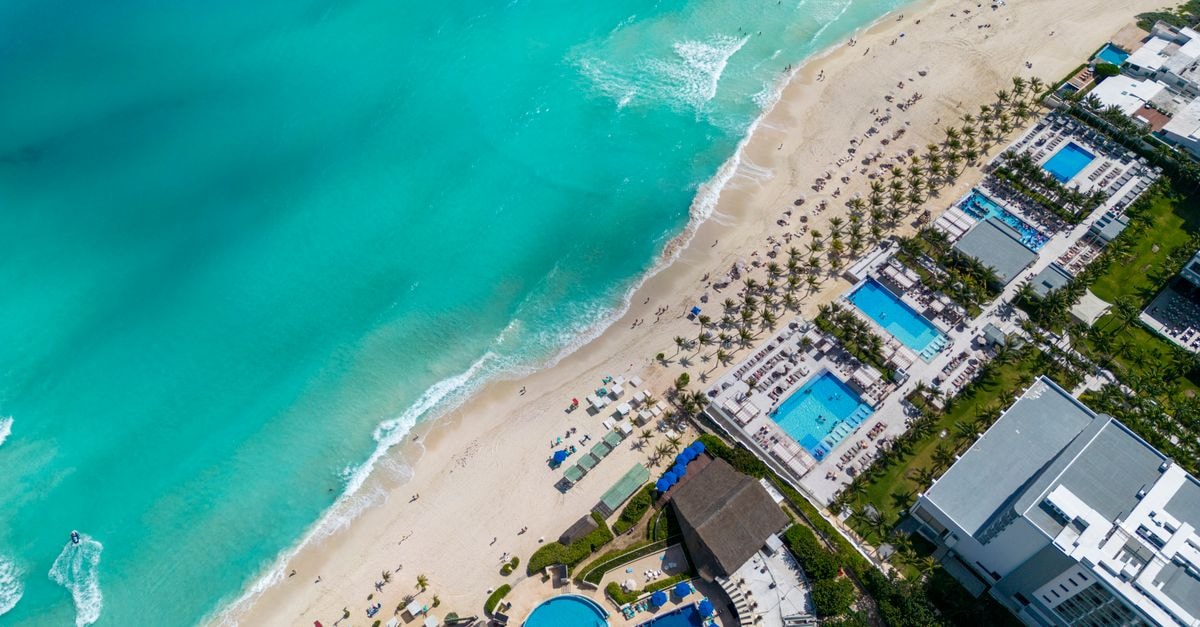 Cancún Travel Guide: Beaches, Buses and Bites Beyond the Hotel Zone Stunning top view of a Cancun beach resort with turquoise water and sandy shore.