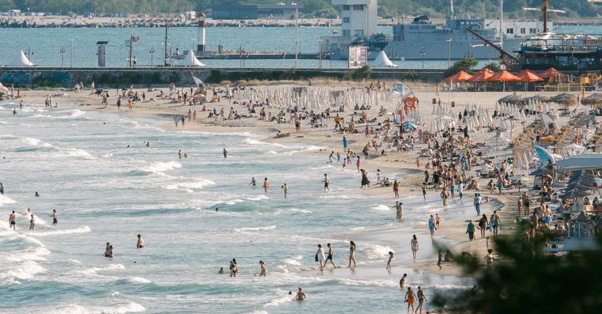 Vlorë Travel Guide: Where City Life Meets the Coast Crowded beach in Bulgaria with people enjoying a sunny day by the shore.