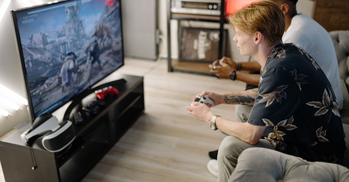 Global reality TV roundup Two friends immersed in playing video games together in a cozy living room.