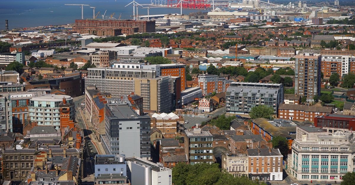 Travelodge Liverpool StoneyCroft in Liverpool: A Handy Pit-Stop on Queens Drive Aerial view of Liverpool cityscape showcasing buildings and docks under a clear sky.