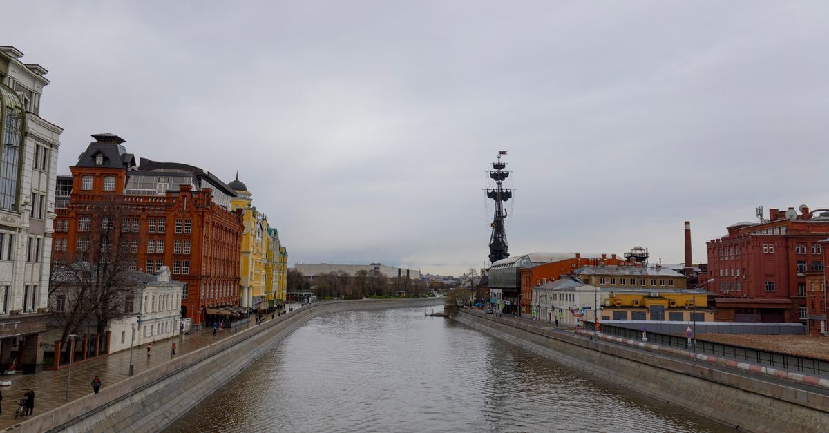Scenic view of Moscow River with Peter the Great statue and colorful buildings.