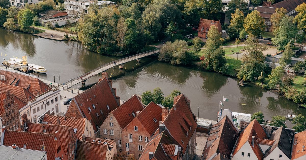 Radisson Blu Hotel, Bremen: A Böttcherstraße Landmark with a Mosaic Ceiling A stunning aerial view of Lübeck's historic rooftops and a serene river with a bridge crossing.