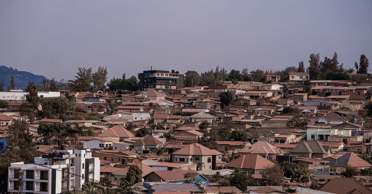 County Comfort in Bungoma: A Moi Avenue Stay Opposite Shariff's Centre Scenic aerial view of dense urban rooftops against a picturesque hilly backdrop under a clear sky.
