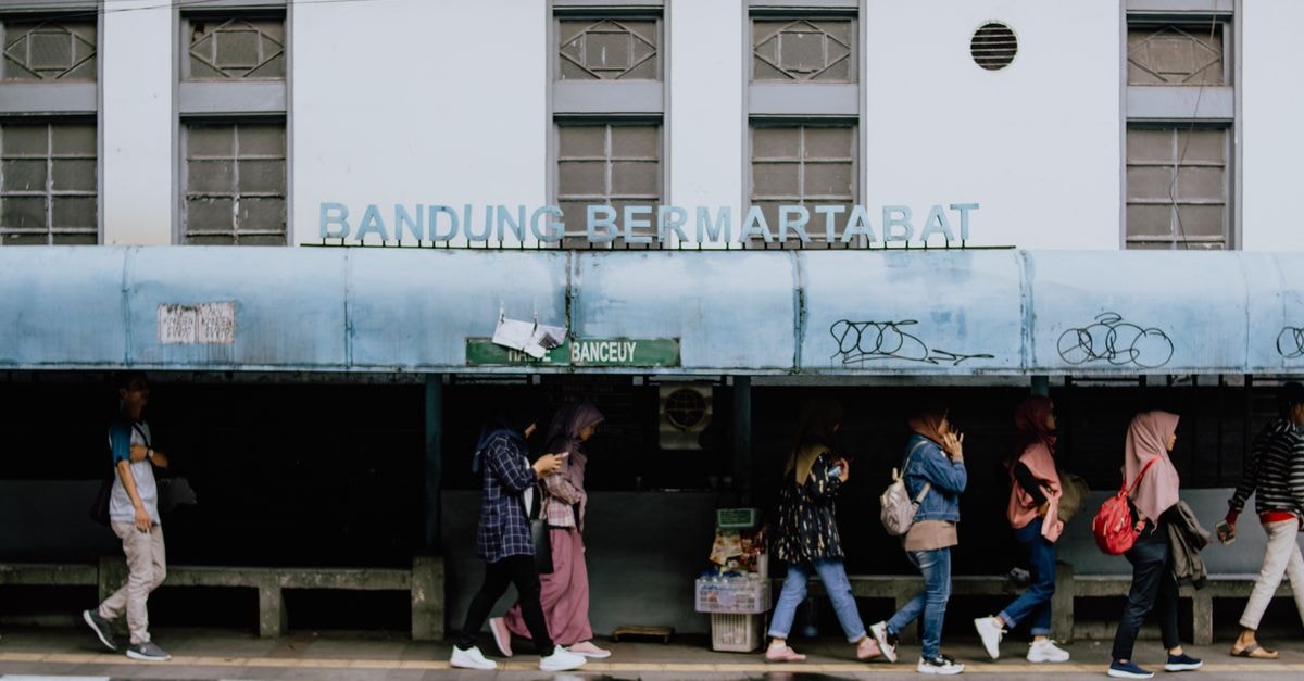 Serang Travel Guide: A Quiet Capital Worth a Stop A lively street scene at a bus station in Bandung, Indonesia with people walking by.