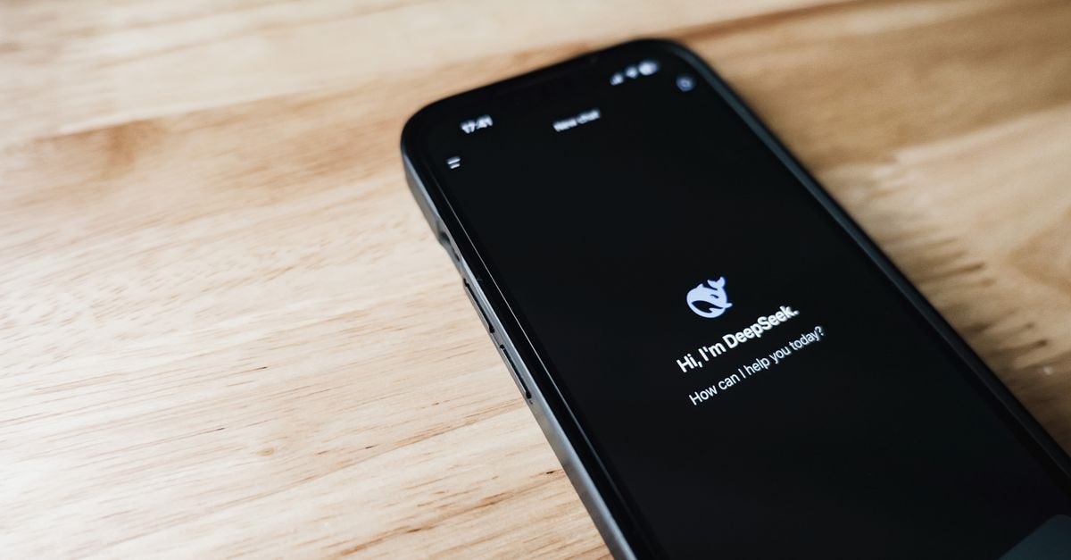 DeepSeek launches V4 public beta as China's AI price competition intensifies Close-up of a smartphone with DeepSeek virtual assistant on screen, placed on a wooden surface.