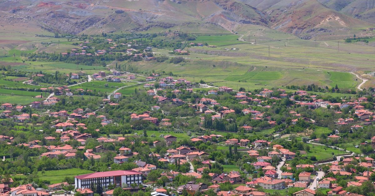 Yaren District Travel Guide: Planning Tips, Costs and Things to Do Aerial view of a picturesque village with red-roofed houses and lush greenery.
