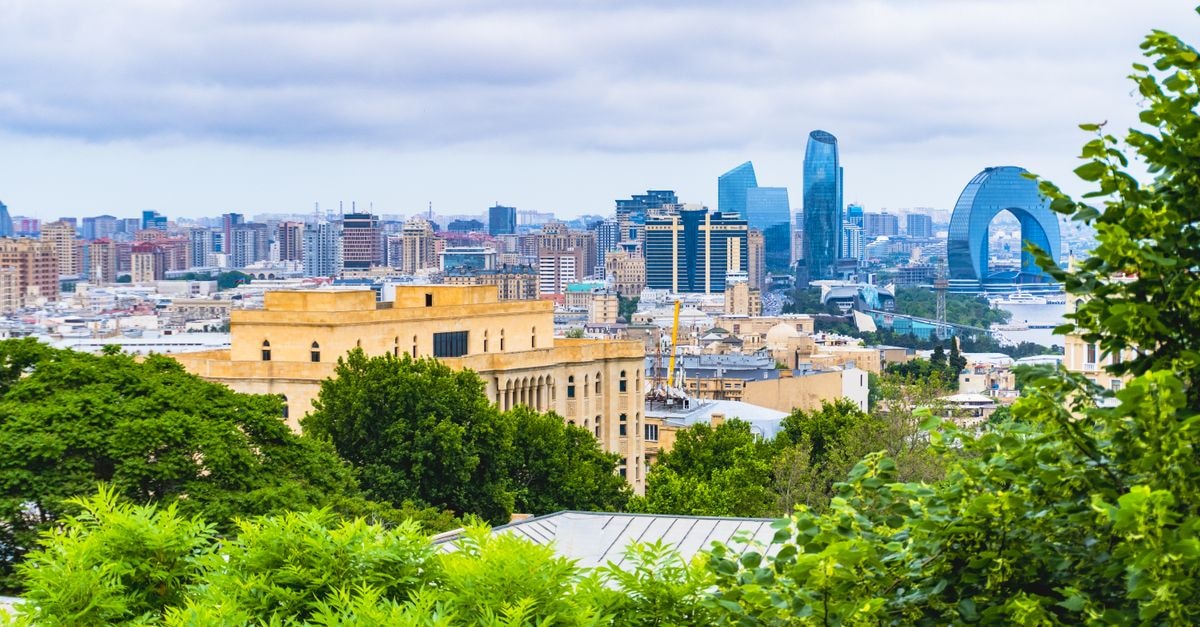 Camping et Auberge Du Puigaudeau et Aziza, Atar — Family-Style Stay Near Azougui Oasis Scenic view of Baku's modern skyline with lush greenery, showcasing iconic buildings under cloudy skies.
