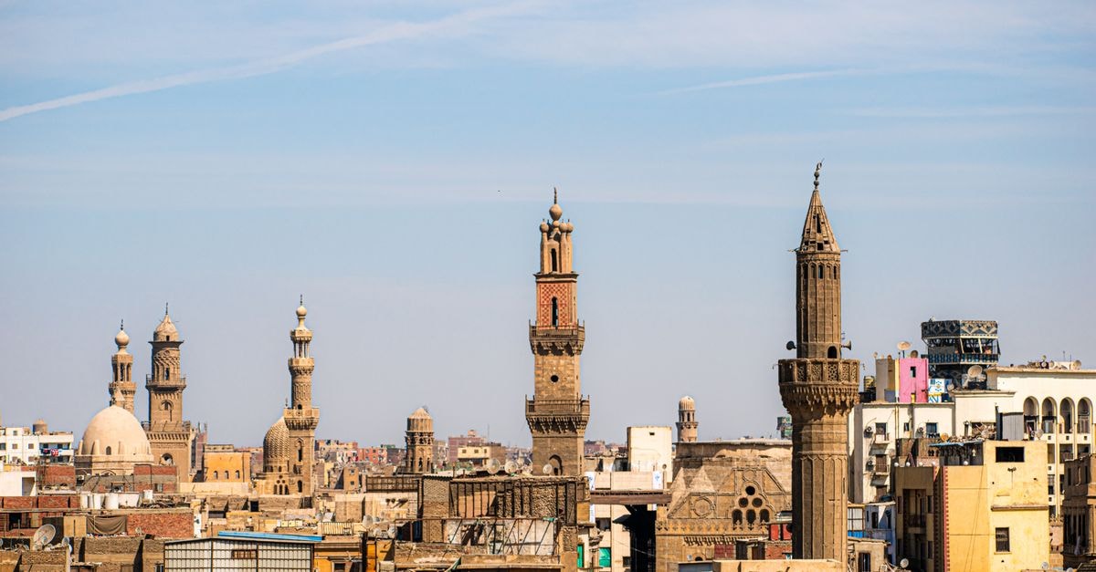 A captivating view of Cairo's skyline featuring historic mosques and minarets under a clear blue sky.