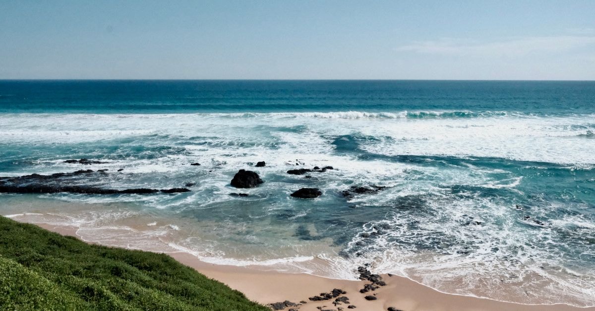 Inhambane Travel Guide: A Quiet Coastal Discovery A tranquil beach scene with rolling waves and a sandy shore, perfect for nature lovers.