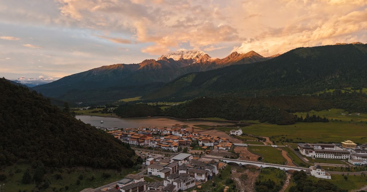 Shangri-La Resort, Shangri-La: Tibetan-Inspired Calm in Diqing Beautiful aerial view of a Tibetan village and mountains during sunset in Tibet, China.