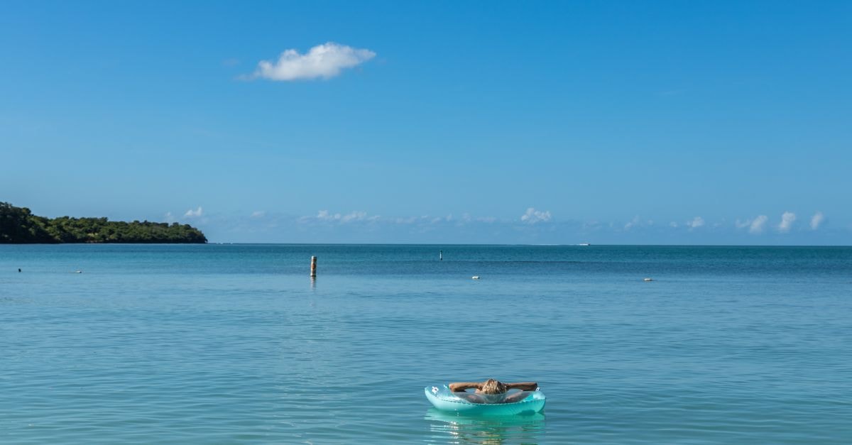 Peaceful ocean scene with a woman relaxing in a buoy at Cabo Rojo, Puerto Rico.
