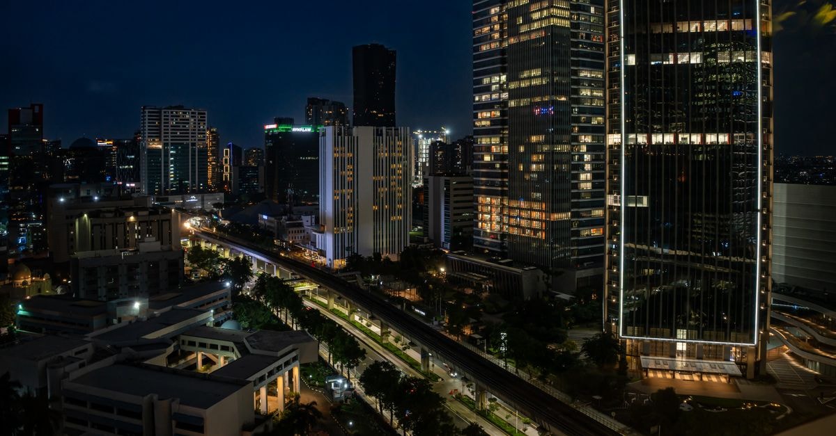 Swiss-Belresidences in Jakarta: Urban Sanctuary on Jalan Muria Raya Captivating view of Jakarta's cityscape featuring illuminated skyscrapers against a night sky.