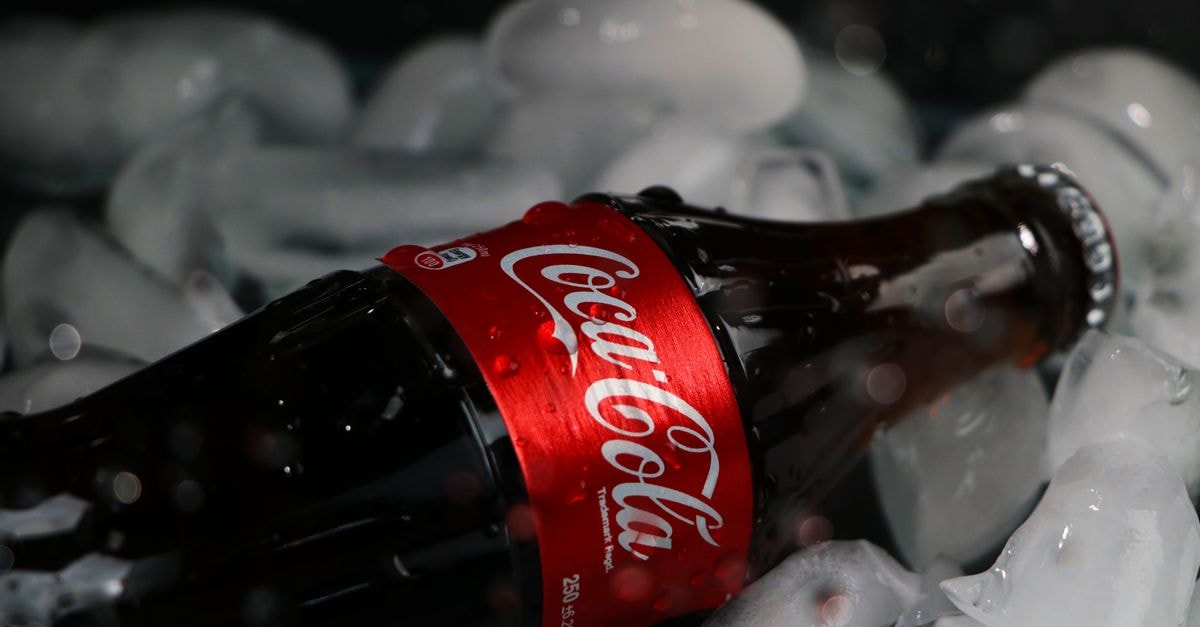 Coca-Cola calls India Diet Coke shortage a 'wonderful problem' as Q2 share slips Chilled Coca-Cola bottle lies amidst melting ice cubes, epitomizing refreshment.