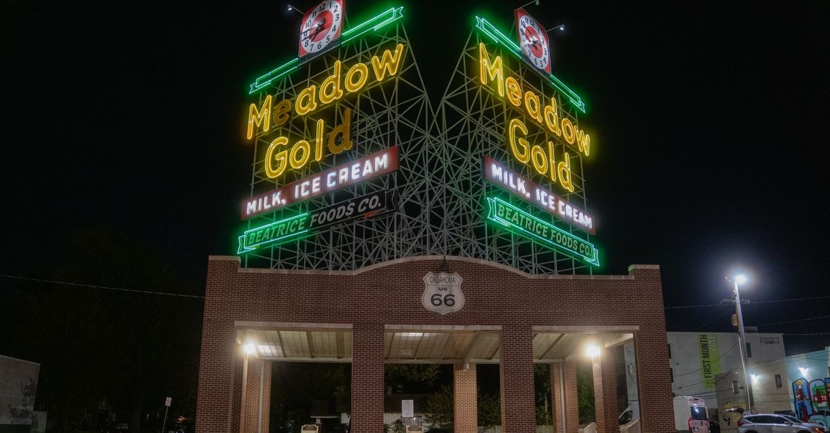 Vibrant neon lights of the historic Meadow Gold sign on Route 66, captured during the night.