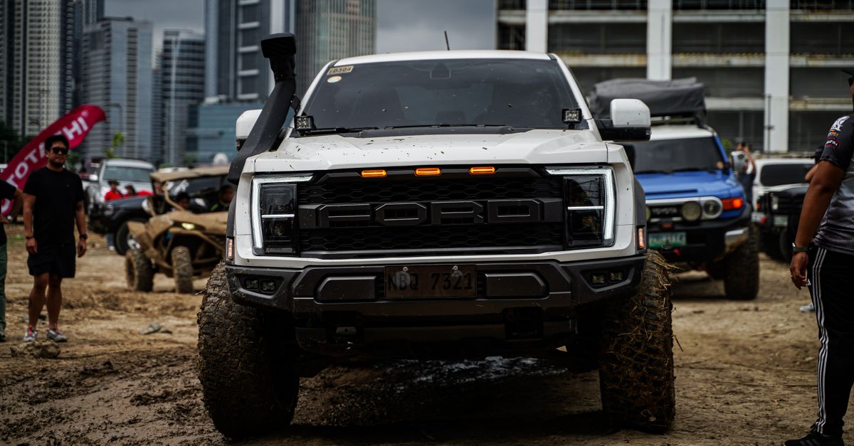 Dynamic off-road vehicles displayed against Pasig's skyscrapers in a lively outdoor event.