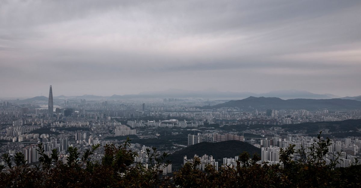 Samwon Plaza Hotel in Anyang-si: Steps from Anyang Subway Station Aerial cityscape of Gwangju-si, South Korea, highlighting urban skyline and surrounding mountains.