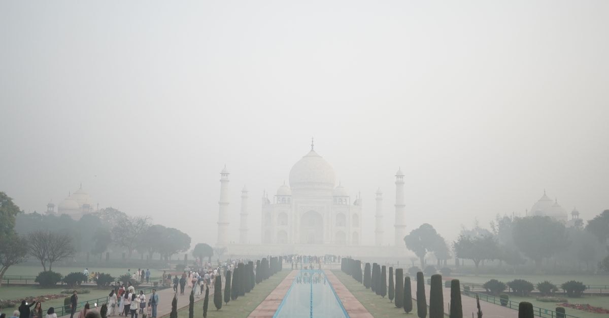 Agra travel guide: slow mornings around the Taj Mahal A misty morning at the Taj Mahal with a crowd of tourists capturing its majestic view.