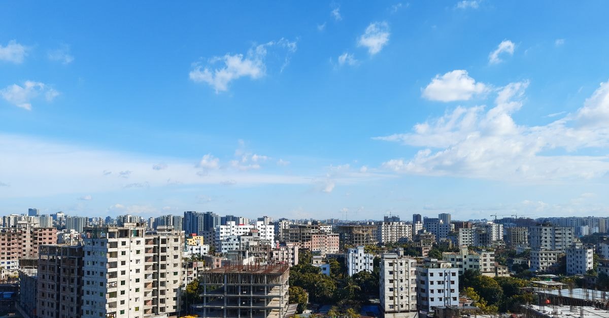 Vivekananda Vidyarthi Bhavan, Dhaka: A Pilgrim Stay by Ramakrishna Mission A stunning panoramic view of Dhaka cityscape under a vibrant blue sky, showcasing urban architecture.
